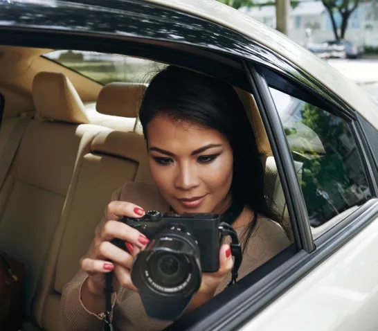 a-lady-taking-a-phicture-with-a-camera-from-her-car-through-the-window